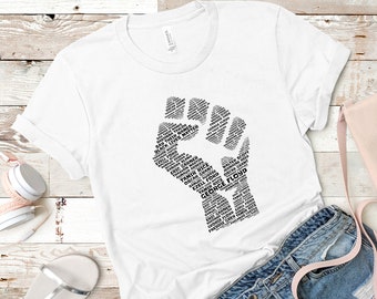Może przedstawiać: Biała koszulka z czarnym wzorem uniesionej pięści. Pięść składa się z takich słów jak "Black Lives Matter", "George Floyd", "Eric Garner", "Tamir Rice" i "Oscar Grant".
