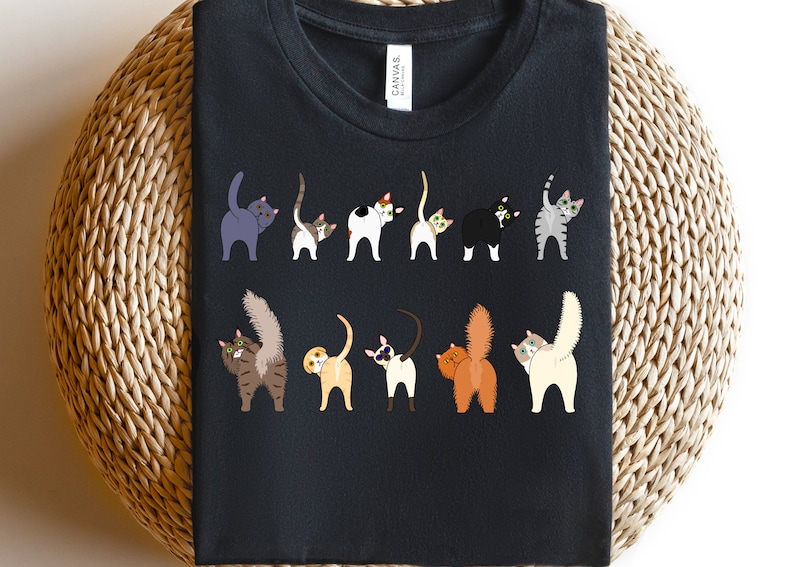 May include: A black t-shirt with a graphic of ten cats with their tails up in the air. The cats are all different colors and breeds.