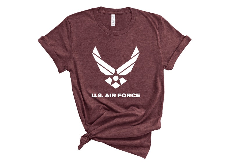 May include: A maroon t-shirt with a white U.S. Air Force logo and the words "U.S. Air Force" printed on the front.