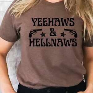 May include: Brown t-shirt with the text "Yeehaws & Hellnaws" in black lettering. Two black pistols and two black stars are on either side of the text.