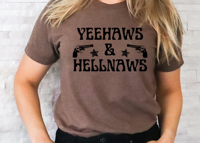 May include: Brown t-shirt with the text "Yeehaws & Hellnaws" in black lettering. Two black pistols and two black stars are on either side of the text.