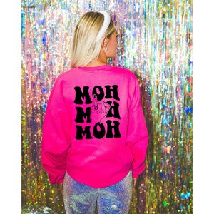 Pode incluir: Camisola rosa com um gr&aacute;fico preto da palavra "MOM" repetida tr&ecirc;s vezes com um dedo do meio no centro.
