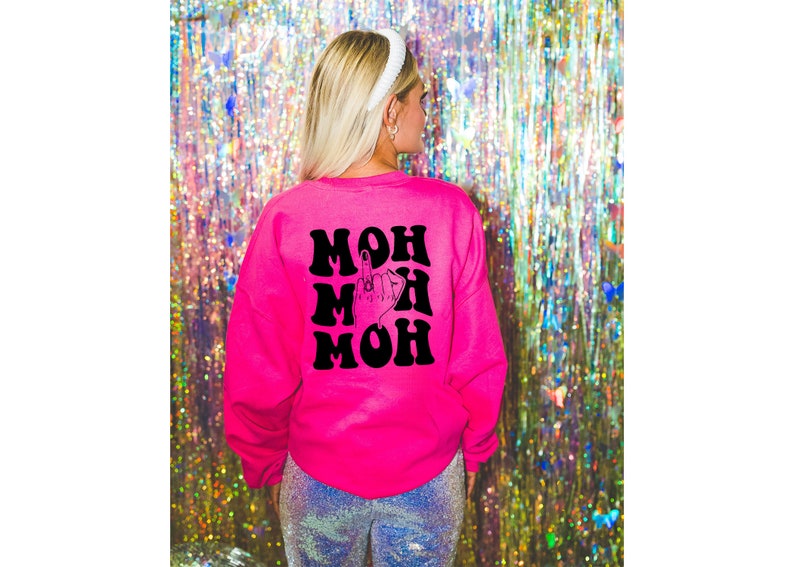 Pode incluir: Camisola rosa com um gr&aacute;fico preto da palavra "MOM" repetida tr&ecirc;s vezes com um dedo do meio no centro.