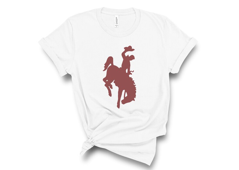 May include: White t-shirt with a maroon silhouette of a cowboy riding a bucking horse.
