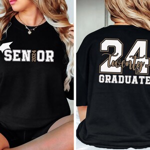 Puede incluir: Sudadera negra con "SENIOR 2024" estampado en la parte delantera, con un gr&aacute;fico de birrete. La parte trasera muestra "24 Twenty GRADUATE" en una combinaci&oacute;n de colores contrastantes. Una prenda elegante para la clase de graduaci&oacute;n de 2024.