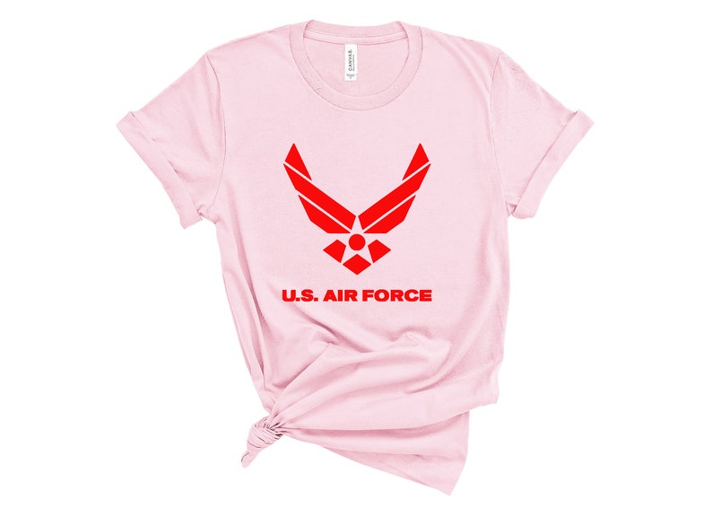 May include: Pink t-shirt with a red U.S. Air Force logo and the words "U.S. Air Force" printed on the front.