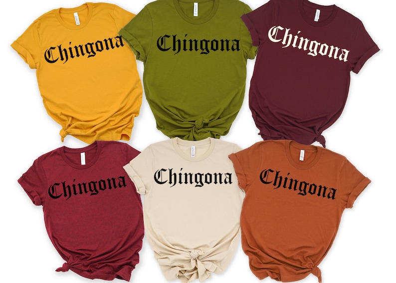 May include: Six t-shirts in different colours with the word "Chingona" printed in black gothic font.