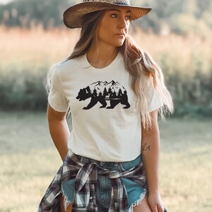 May include: White t-shirt with a black silhouette of a bear with mountains and trees inside the bear's body.