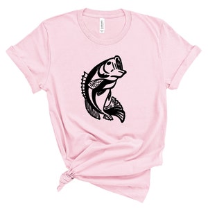 以下が含まれることがあります： 水から飛び出すバスの黒いシルエットが描かれたピンクのTシャツです。
