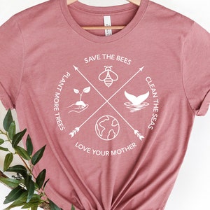 Może przedstawiać: R&oacute;żowy T-shirt z białym nadrukiem przedstawiającym pszczołę, wieloryba, drzewo i Ziemię. Tekst na koszulce brzmi: "Save the Bees", "Plant More Trees", "Clean the Seas" i "Love Your Mother".