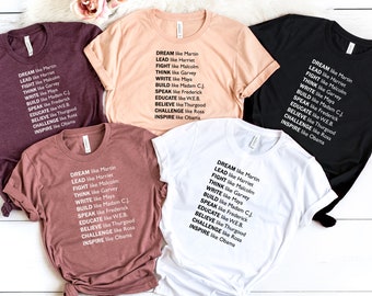 May include: Five t-shirts in different colors with the text "DREAM like Martin, LEAD like Harriet, FIGHT like Malcolm, THINK like Garvey, WRITE like Maya, BUILD like Madam CJ, SPEAK like Frederick, EDUCATE like WEB, BELIEVE like Thurgood, CHALLENGE like Rosa, INSPIRE like Obama" printed on them.