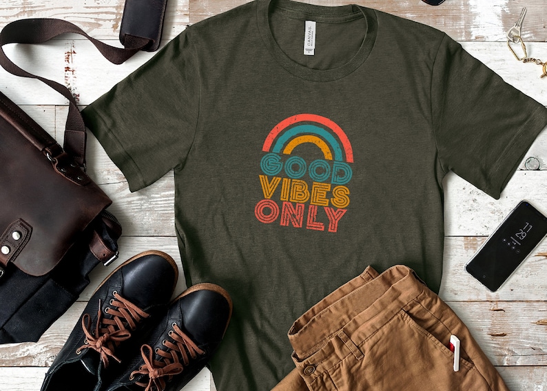 May include: A green t-shirt with a rainbow graphic and the text "GOOD VIBES ONLY" in a retro font.