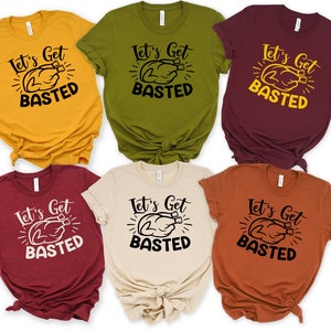 May include: Six different colored t-shirts with the text "Let's Get Basted" and a graphic of a turkey. The shirts are in the colors mustard yellow, olive green, burgundy, maroon, beige, and burnt orange.