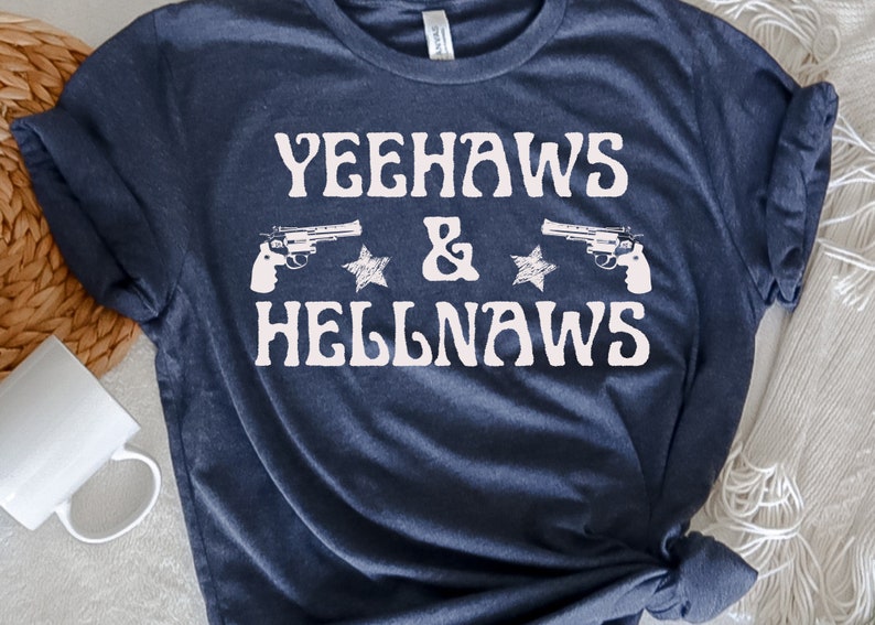 May include: A navy blue t-shirt with the text "Yeehaws & Hellnaws" in white, featuring two stylized pistols and stars.