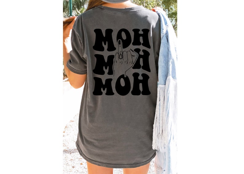 Pode incluir: Uma camiseta cinza-chumbo com um gr&aacute;fico preto da palavra "MOH" repetida tr&ecirc;s vezes com um dedo do meio em um anel entre as palavras.