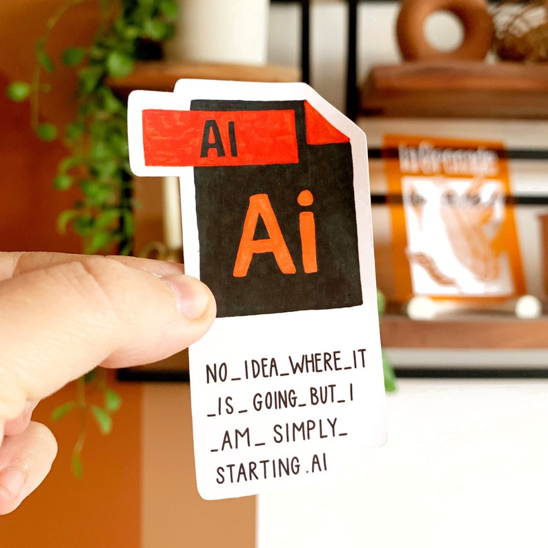 K&ouml;nnte beinhalten: Ein wei&szlig;er Aufkleber mit einem schwarzen und orangefarbenen Adobe Illustrator-Dateisymbol und dem Text "NO_IDEA_WHERE_IT_IS_GOING_BUT_I_AM_SIMPLY_STARTING.AI"