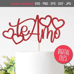 Puede incluir: Topper de pastel rojo con purpurina con las palabras "te amo" y tres corazones. El topper está en un pastel blanco.