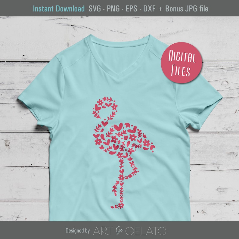 Op de afbeelding: Een lichtblauw T-shirt met een roze flamingo-ontwerp gemaakt van bloemen en harten. Het ontwerp is wit omrand. De tekst "DIGITALE BESTANDEN" staat op een roze cirkel in de rechterbovenhoek. De tekst "Ontworpen door ART & GELATO" staat onderaan de afbeelding.
