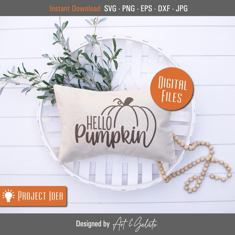 May include: A white pillow with the text "HELLO PUMPKIN" and a brown outline of a pumpkin on it. The pillow is sitting on a white wicker basket with a sprig of greenery.