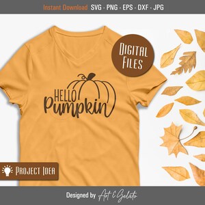 May include: A digital design featuring a pumpkin with the text "Hello Pumpkin" in a brown font on a yellow t-shirt. The design is surrounded by fall leaves.