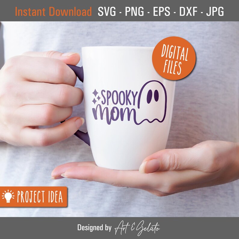 May include: White ceramic mug with a purple design that says "SPOOKY mom" with a ghost illustration. The mug is being held by a person's hands.