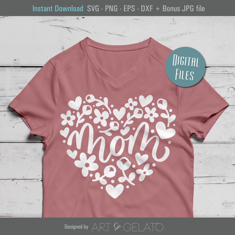Pode incluir: Uma camiseta rosa com um design de cora&ccedil;&atilde;o branco com a palavra "mom" cercada de flores e cora&ccedil;&otilde;es. O texto "Digital Files" est&aacute; em um c&iacute;rculo no lado direito da camiseta. O texto "Designed by ART & GELATO" est&aacute; na parte inferior da camiseta.