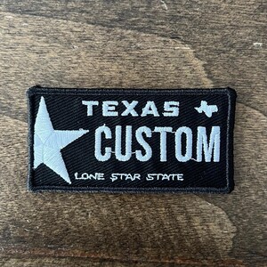 May include: Black and white embroidered patch with a white star and the text "TEXAS CUSTOM LONE STAR STATE".