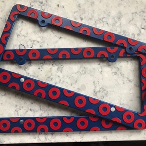 May include: Two blue license plate frames with a red donut pattern.