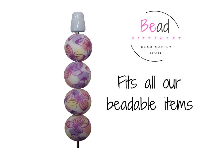 May include: A stack of five colorful beads with a butterfly pattern. The beads are strung on a white cord and have a white cap on top. The text "Fits all our beadable items" is written below the beads.
