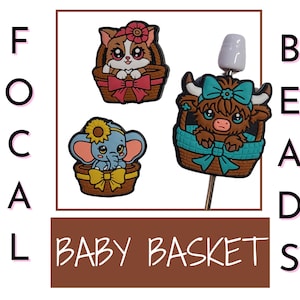 以下が含まれることがあります： 画像には、漫画スタイルのフォーカルビーズが3つあります。1つはピンクのリボンが付いたバスケットに入った猫、もう1つはヒマワリが付いた象、3つ目はターコイズのリボンが付いたハイランド牛です。「BABY BASKET」という文字も表示されています。