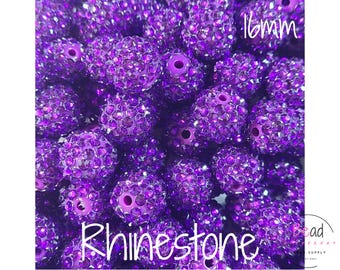 May include: A collection of round purple beads covered in small rhinestones, each featuring a central hole. The text 16mm is visible in the top right corner, and the word Rhinestone is printed in white script across the bottom.
