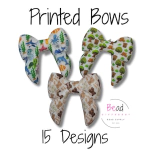 May include: Three fabric bows with printed patterns including sea life, trees, and teddy bears. The text Printed Bows and 15 Designs is visible. A logo for Bead Different Bead Supply is present. The bows feature white backgrounds with colorful graphics.