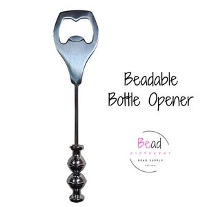 May include: Silver bottle opener with a beaded handle. The opener is designed to be used with beads. The text "Beadable Bottle Opener" is visible in the image.