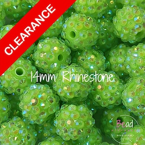 May include: A collection of lime green 14mm rhinestone beads featuring a spherical shape with a central hole. The beads are covered in small, reflective, multi-faceted crystals that catch the light. A red diagonal banner reads CLEARANCE.