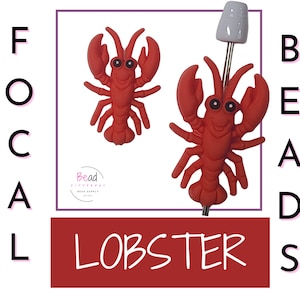 Op de afbeelding: Twee rode kreeftvormige kralen met zwarte ogen en lachende gezichten. Eén kraal is bevestigd aan een zilveren speld met een witte bovenkant. De afbeelding bevat de tekst "FOCAL BEADS" en "LOBSTER" in een rode rechthoek en een logo voor "Bead Different Bead Supply".