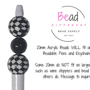 May include: A pen with a white and black checkered bead design. The pen has a white top and a black bead in the middle. The text on the image says "Bead Different Bead Supply". The text also says "20mm Acrylic Beads WILL fit on our Beadable Pens and Keychains."
