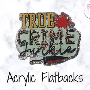 May include: Acrylic flatback with the text "TRUE CRIME Junkie" in a stylized design. The design includes a leopard print pattern, a red splatter, and a knife. The edges are outlined with glitter.