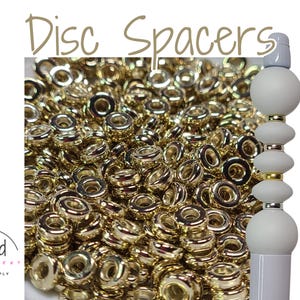 May include: A close-up of a large pile of gold-colored disc spacers. The spacers are 6mm in diameter and are perfect for jewelry making. The text "KC Gold 6mm" is visible in the image.