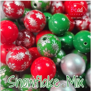 May include: A mix of red, green, and silver beads. Some beads are solid colors, while others feature a snowflake design. The text "Snowflake Mix" is visible in the image. These beads are suitable for jewelry making and holiday crafts.