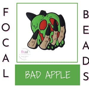 May include: A green apple with a skull face and dripping red liquid, with a hand reaching out with long, sharp nails. The apple is surrounded by a black outline. The text "BAD APPLE" is written below the image.