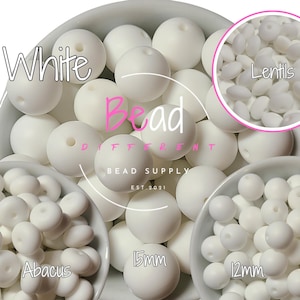 以下が含まれることがあります： 白のシリコンビーズが3つのサイズで表示されています。12mm、15mm、そろばんビーズです。ビーズは白い表面のボウルに表示されています。画像の中央に「White Bead」というテキストが表示されています。