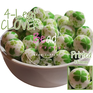 May include: A bowl filled with white and green 15mm silicone beads with a four-leaf clover print.  The beads are labeled "4-Leaf Clover Bead Printed 15mm".