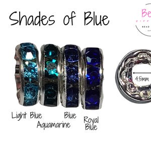 May include: Four silver spacer beads with different shades of blue rhinestones. The beads are labeled "Light Blue", "Aquamarine", "Blue", and "Royal Blue". The beads are 10mm in diameter and have a 4.5mm hole.