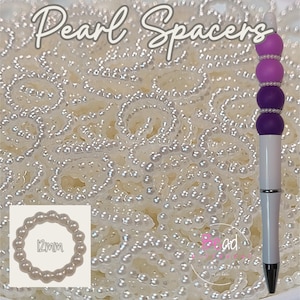 May include: White pearl spacers for jewelry making. The spacers are 12mm in diameter. The image also shows a pen with purple and white accents.