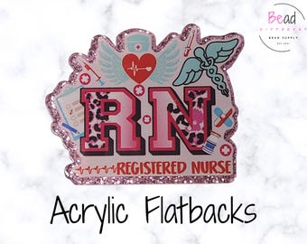 May include: A pink glitter-edged acrylic flatback featuring the letters RN with a leopard print pattern. The design includes a red heart with wings, a medical caduceus, a clipboard, a syringe, a bandage, and a vial, with the text REGISTERED NURSE.