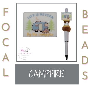 May include: A white ceramic tile with the text "Life is better by the campfire" and a cartoon illustration of a camper van and a campfire. A white pen with a brown and white camper van charm.