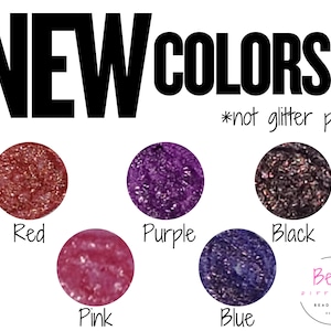 May include: A graphic display titled NEW COLORS *not glitter pens featuring five circular swatches of textured material in red, purple, black, pink, and blue. Each color is labeled below its respective circle. A logo for Bead Different Bead Supply is in the corner.