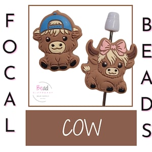 以下が含まれることがあります： 茶色の牛のフォーカルビーズが2つ。1つの牛は青い野球帽をかぶり、もう1つの牛はピンクのリボンをつけています。ビーズは白い背景にあり、側面には「Focal Beads」と「Cow」の文字が書かれています。