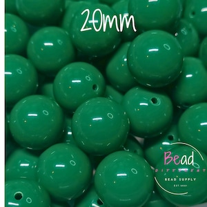 May include: A close-up shot of numerous glossy, emerald green beads. Each bead is approximately 20mm in diameter and has a small hole. The image also includes the text "20mm" and the logo "Bead Different Bead Supply Est. 2001".