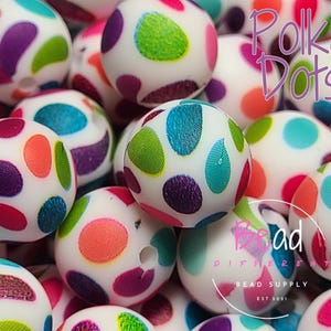 Peut inclure: Gros plan sur des perles rondes blanches avec des pois multicolores. Les perles sont éparpillées sur une surface et certaines se chevauchent. Le texte "Polka Dots" est visible dans le coin supérieur droit de l'image. Le texte "Bead Different Bead Supply Est 2021" est visible dans le coin inférieur droit de l'image.
